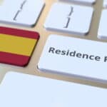 Residence Permit text and flag of Spain on the buttons on the computer keyboard. Immigration related conceptual 3D rendering